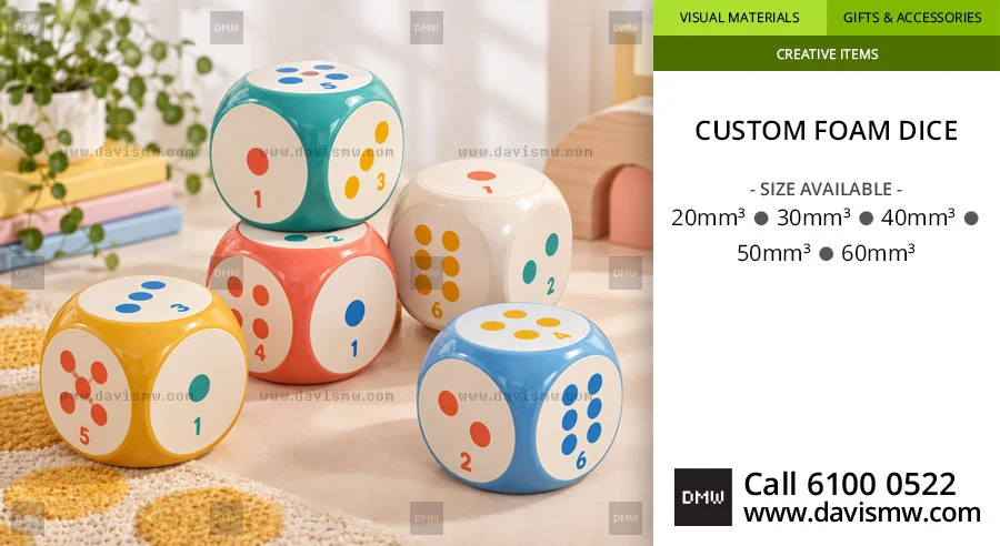 Four colourful foam dice in teal, coral, yellow and blue showing printed numbers